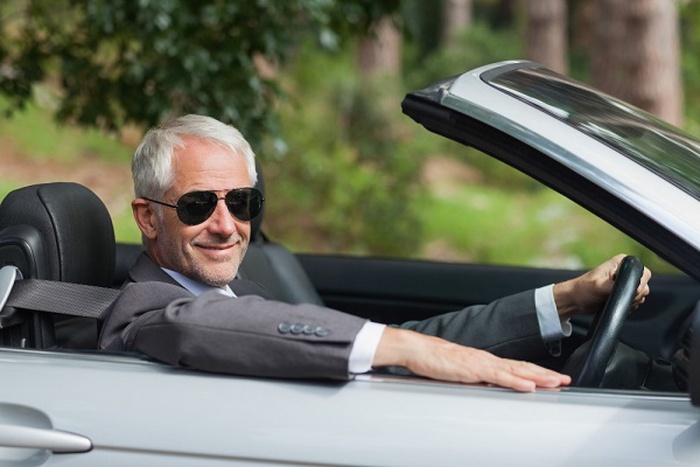 Un hombre de éxito conduce su coche deportivo.
