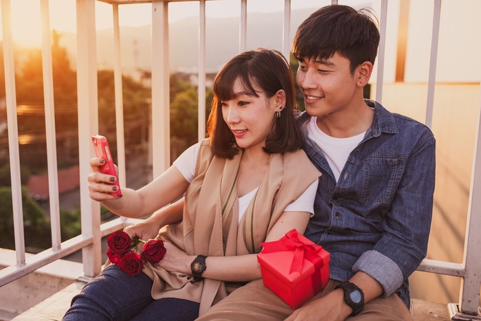 Magkasintahan mula sugar dating Philippines na naglalakad habang magkahawak at may hawak na mga lobo, nagpapakita ng saya at tunay na koneksyon