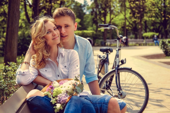 Blonde with flowers smiling at handsome man