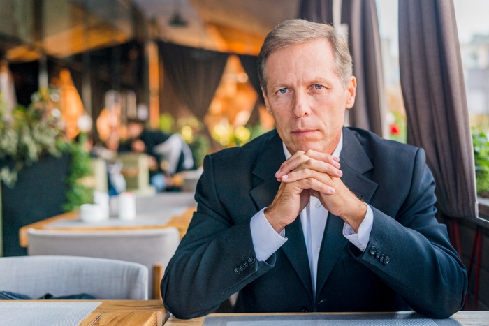 Sugardaddy sitting thoughtfully in a restaurant