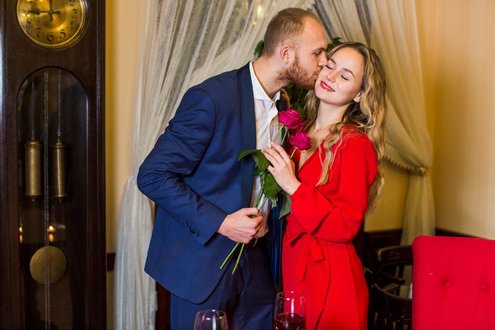 Romantic kiss with roses at dinner