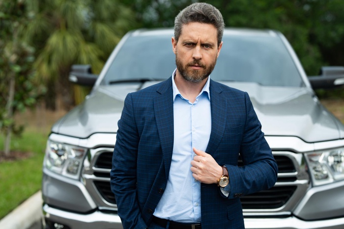 Executive by luxury car for business meeting